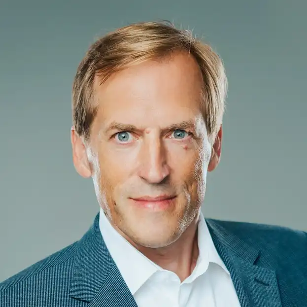 Ein Porträt von Michael Biermann in Anzug und weißem Hemd.