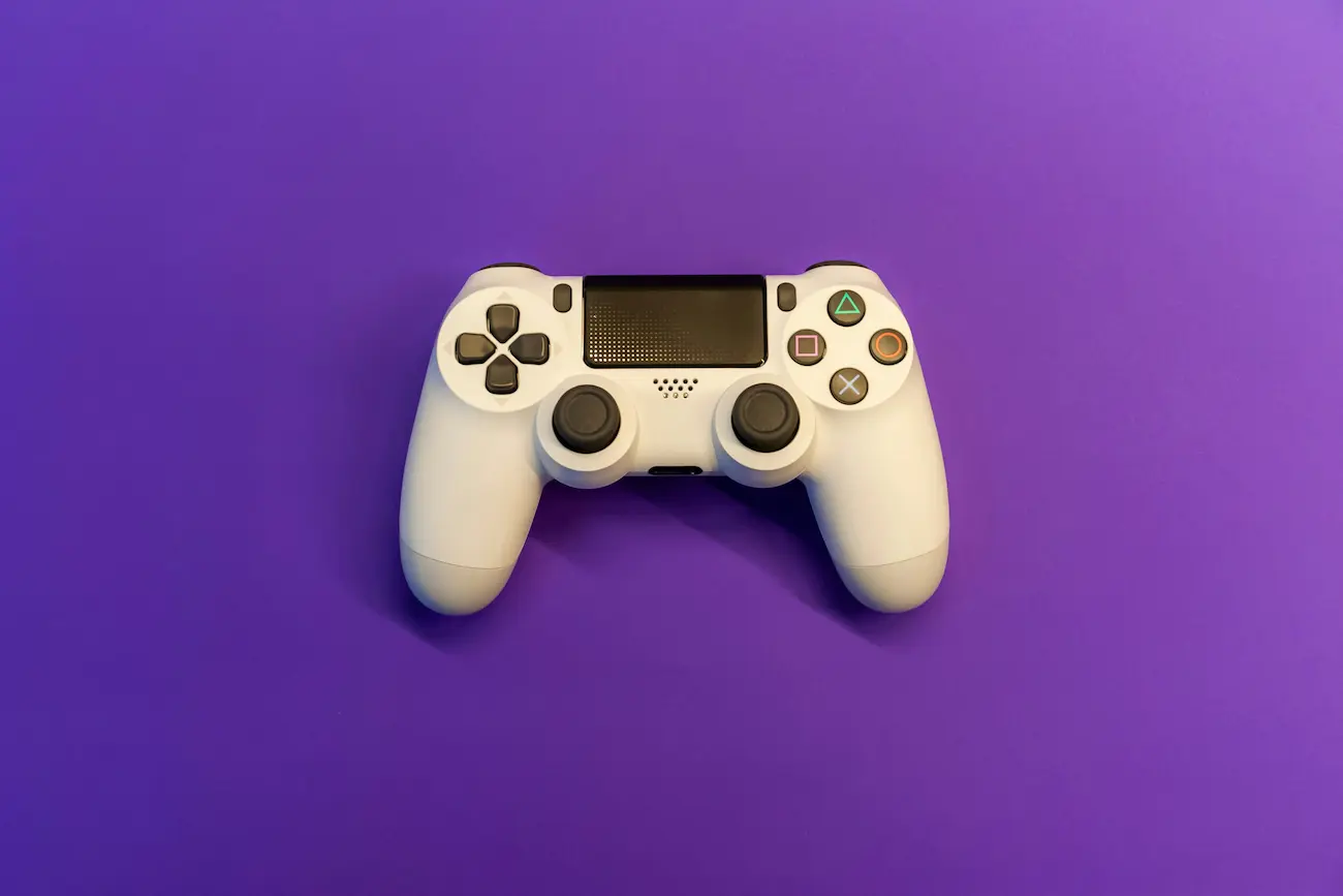 Weißer Gaming-Controller auf violettem Hintergrund – Symbolbild für Crowdtesting, Quality Assurance und Usability-Tests in der Gaming-Branche.